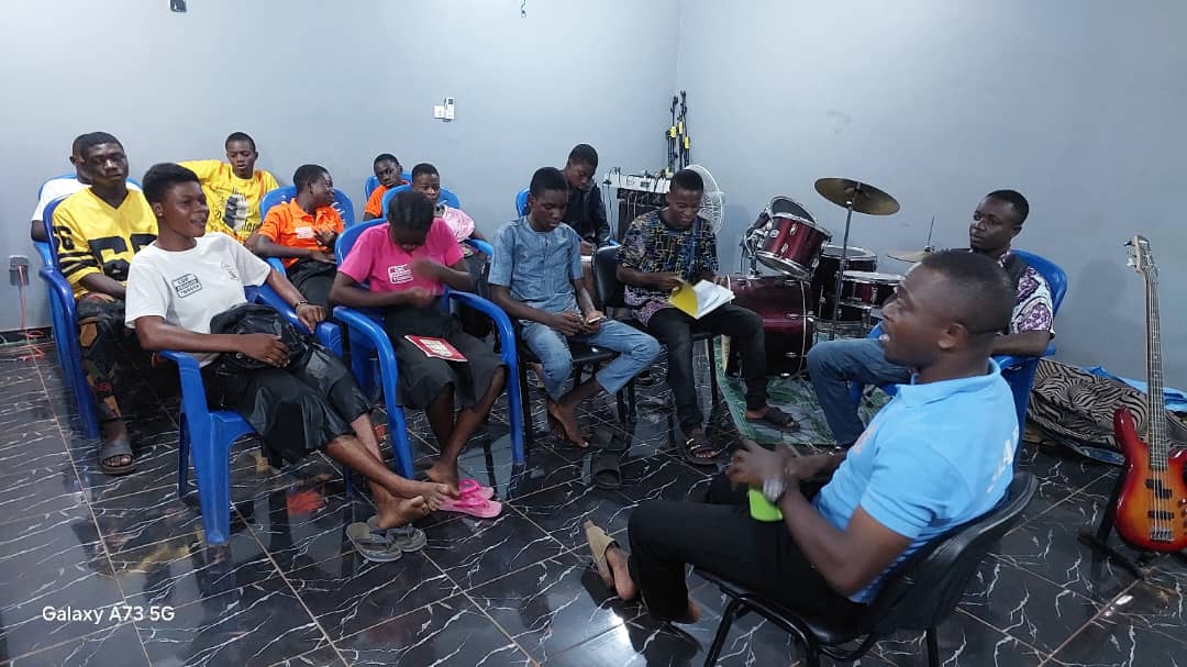 Cercle de discussion entre jeunes et animateur dans une salle du centre
