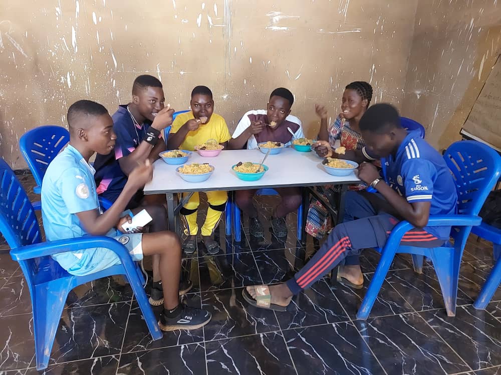 Des jeunes partagent un repas autour d'une table au centre